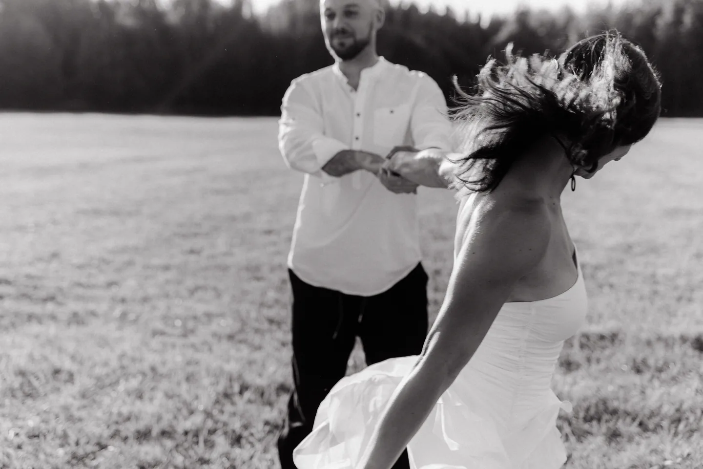 Пара обнимается на фоне зелёной аллеи, солнечный день