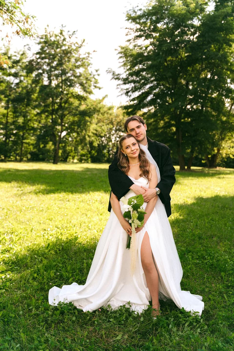 Счастливые молодожёны обнимаются на ступенях, завершение прогулки